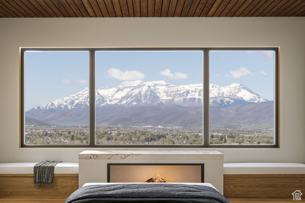 Bedroom with a mountain view, wood finished floors, and wooden ceiling