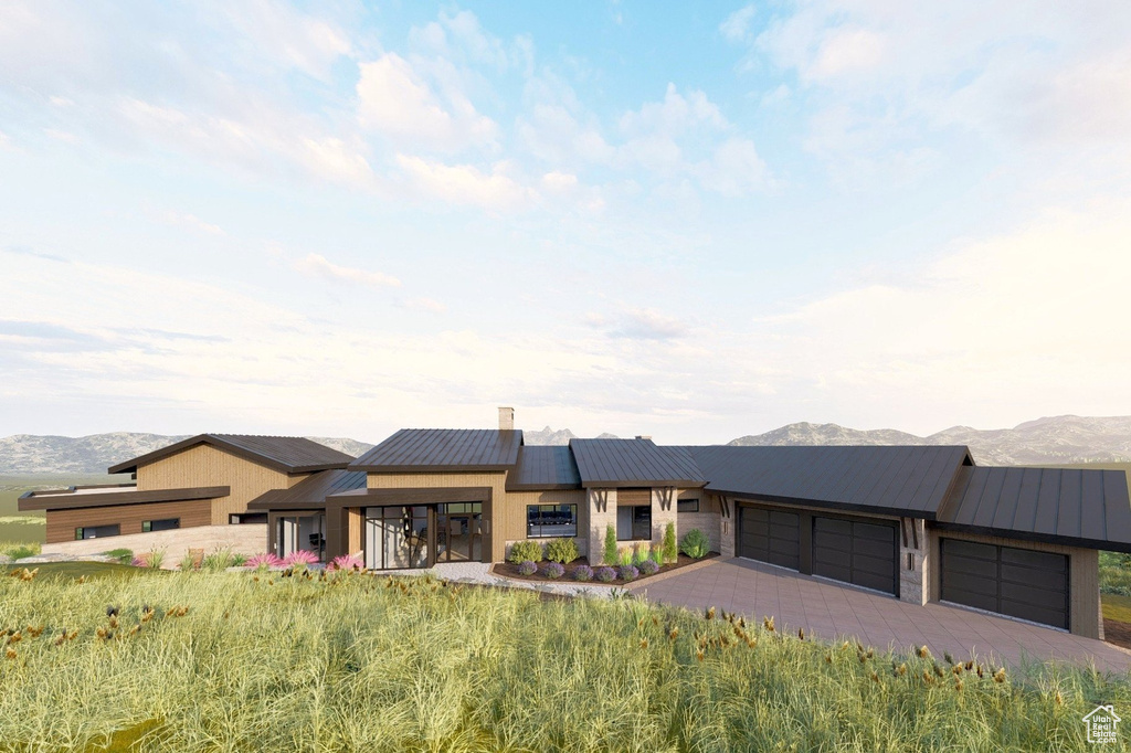 Prairie-style house with a garage, a mountain view, a standing seam roof, driveway, and metal roof