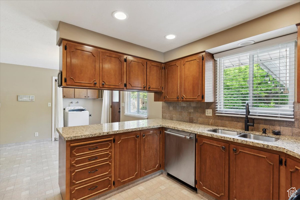 Kitchen featuring light floors, a wealth of natural light, a sink, and dishwasher