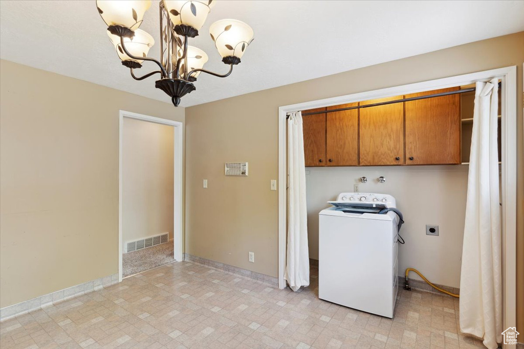 Laundry area featuring visible vents, washer / dryer, baseboards, a chandelier, and cabinet space