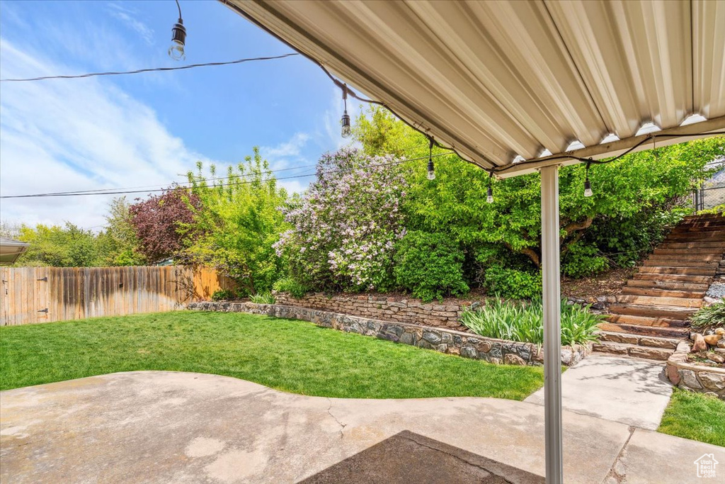 View of yard featuring a patio, fence, and stairs