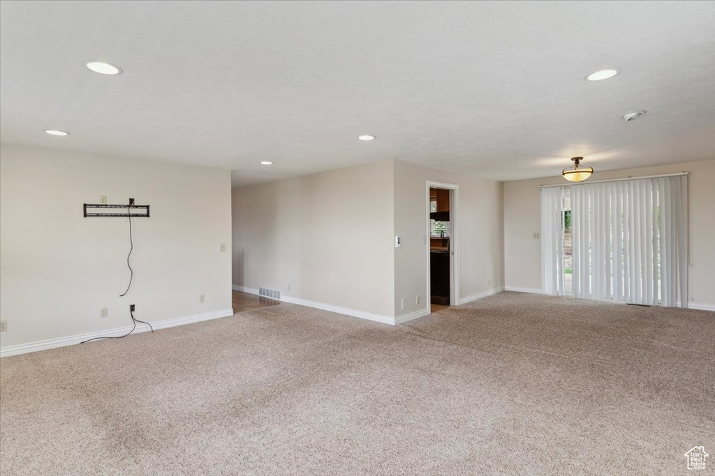 Unfurnished room featuring visible vents, recessed lighting, baseboards, and light carpet