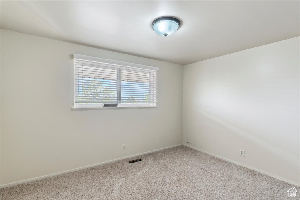 Spare room with carpet floors, baseboards, and visible vents