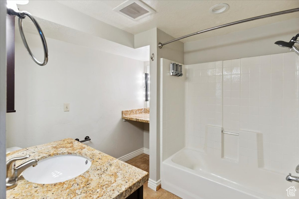 Full bath with visible vents, vanity, shower / bathtub combination, baseboards, and tile patterned floors
