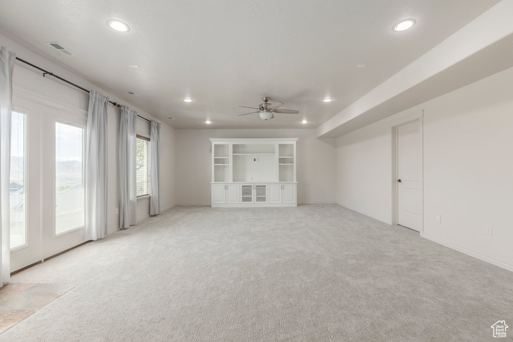Unfurnished living room with recessed lighting, a ceiling fan, visible vents, light carpet, and baseboards