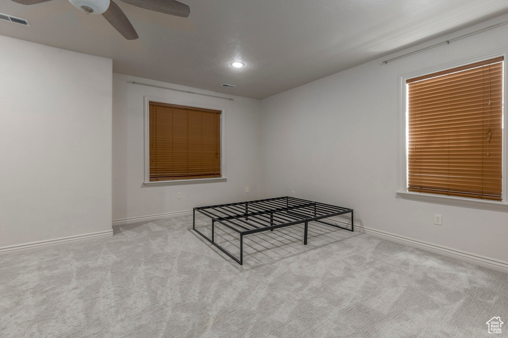 Unfurnished bedroom featuring recessed lighting, ceiling fan, carpet flooring, baseboards, and visible vents