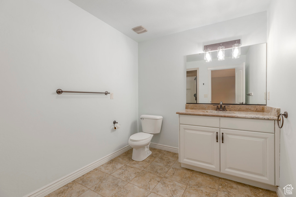 Bathroom with baseboards, toilet, and vanity