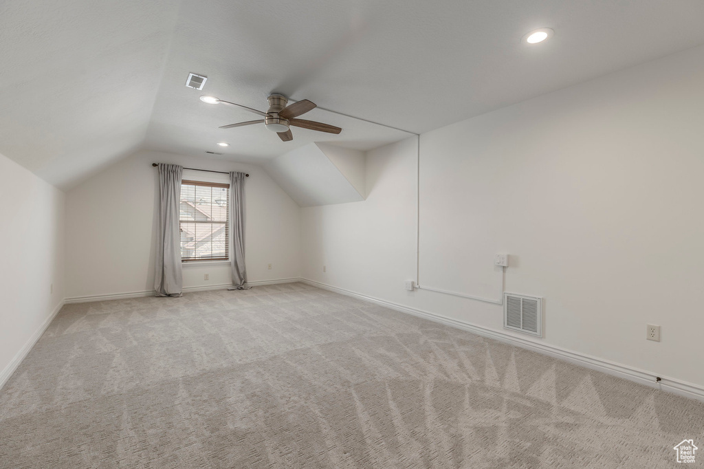 Bonus room with carpet flooring, visible vents, ceiling fan, and vaulted ceiling