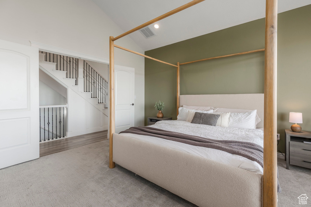 Carpeted bedroom featuring visible vents, recessed lighting, and high vaulted ceiling