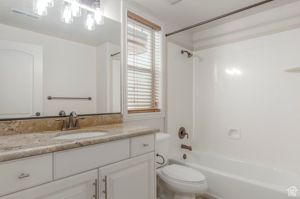 Bathroom with a wealth of natural light, toilet, shower / tub combination, vanity, and visible vents