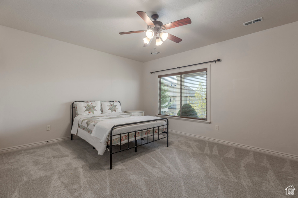 Bedroom with visible vents, ceiling fan, baseboards, and carpet floors