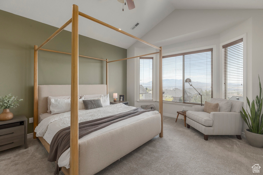 Carpeted bedroom with a ceiling fan, visible vents, vaulted ceiling, and baseboards