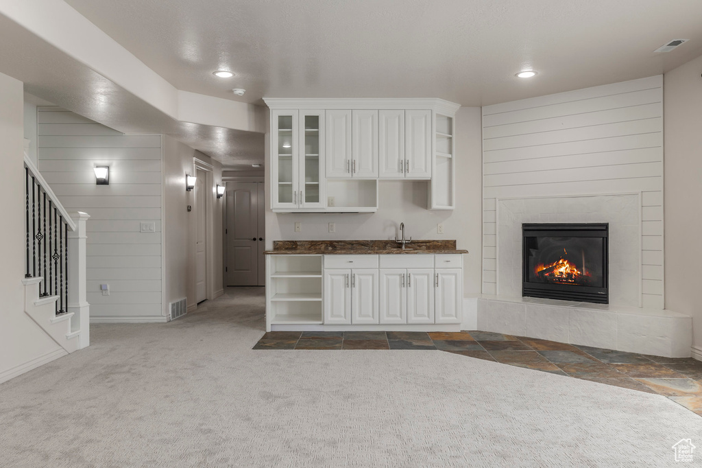 Unfurnished living room with recessed lighting, stairs, a sink, visible vents, and dark carpet