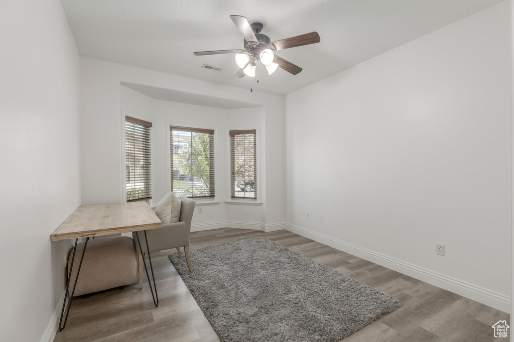 Home office featuring baseboards, visible vents, a ceiling fan, and light wood-style floors