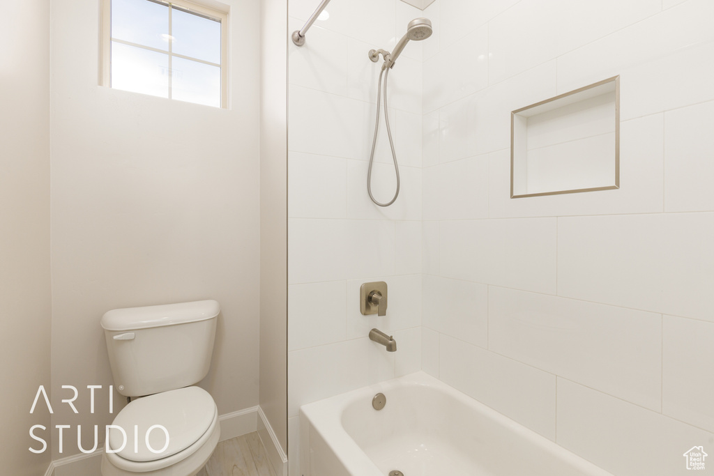 Full bath with baseboards, toilet, and shower / bathtub combination
