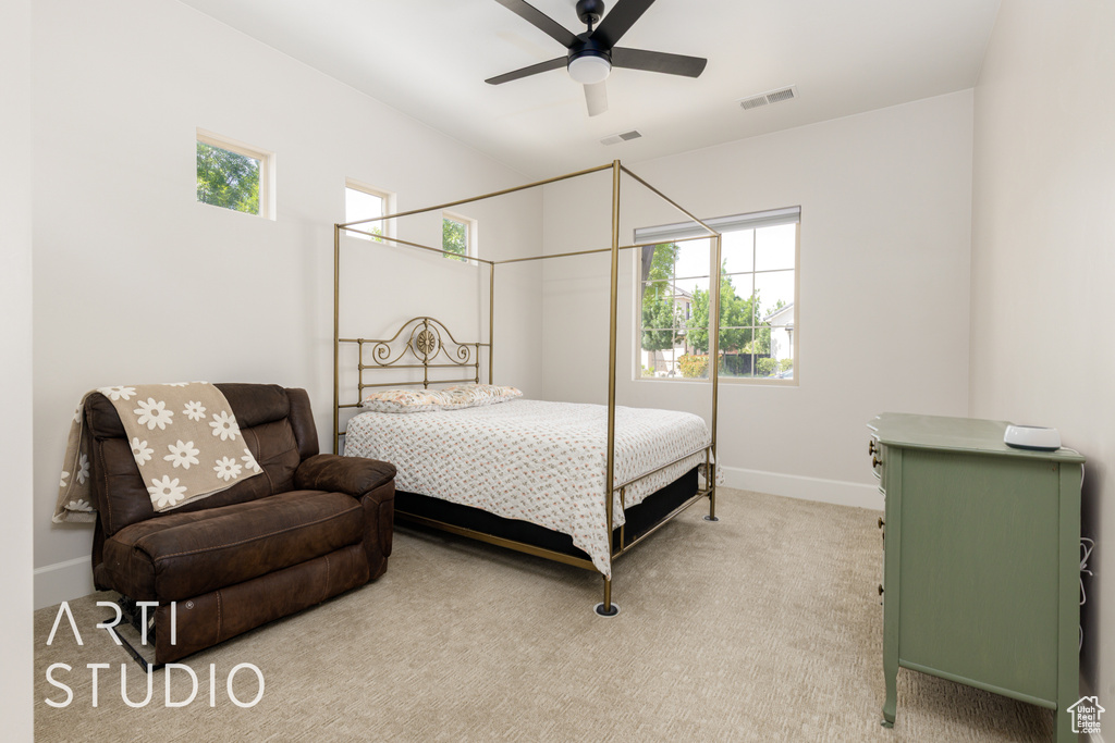 Bedroom with baseboards, visible vents, light carpet, and multiple windows