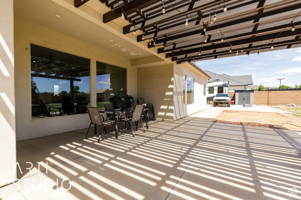 View of patio with a pergola, outdoor dining space, and fence