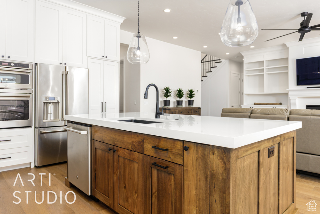 Kitchen with recessed lighting, appliances with stainless steel finishes, a sink, light wood-type flooring, and a ceiling fan