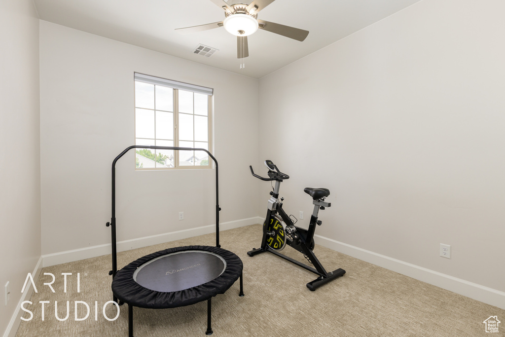 Exercise room with baseboards, visible vents, a ceiling fan, and carpet