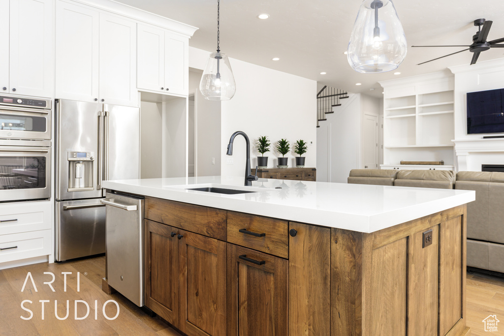 Kitchen with recessed lighting, stainless steel appliances, light wood-style floors, a sink, and a ceiling fan