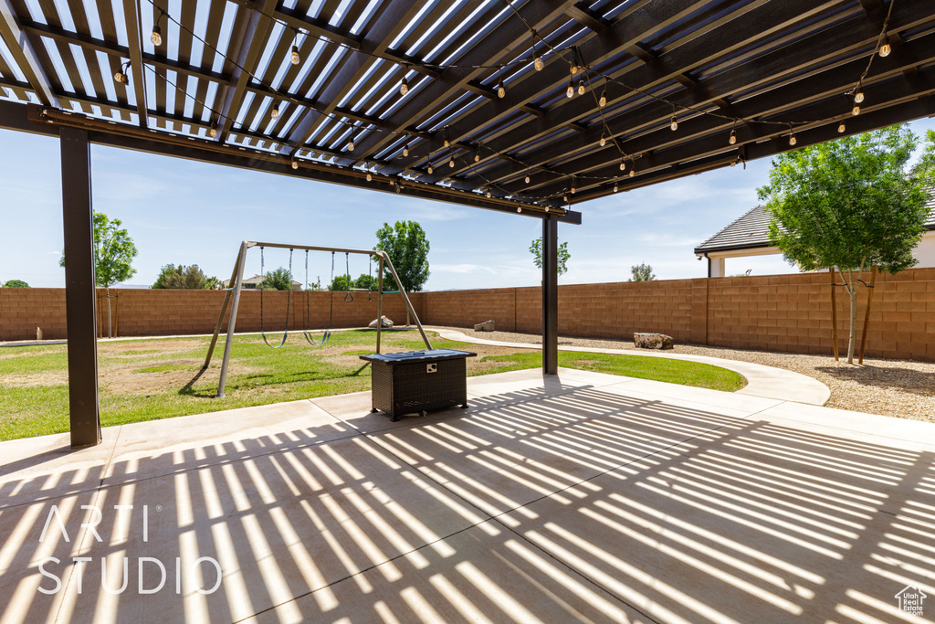 View of patio with a pergola, a playground, and a fenced backyard