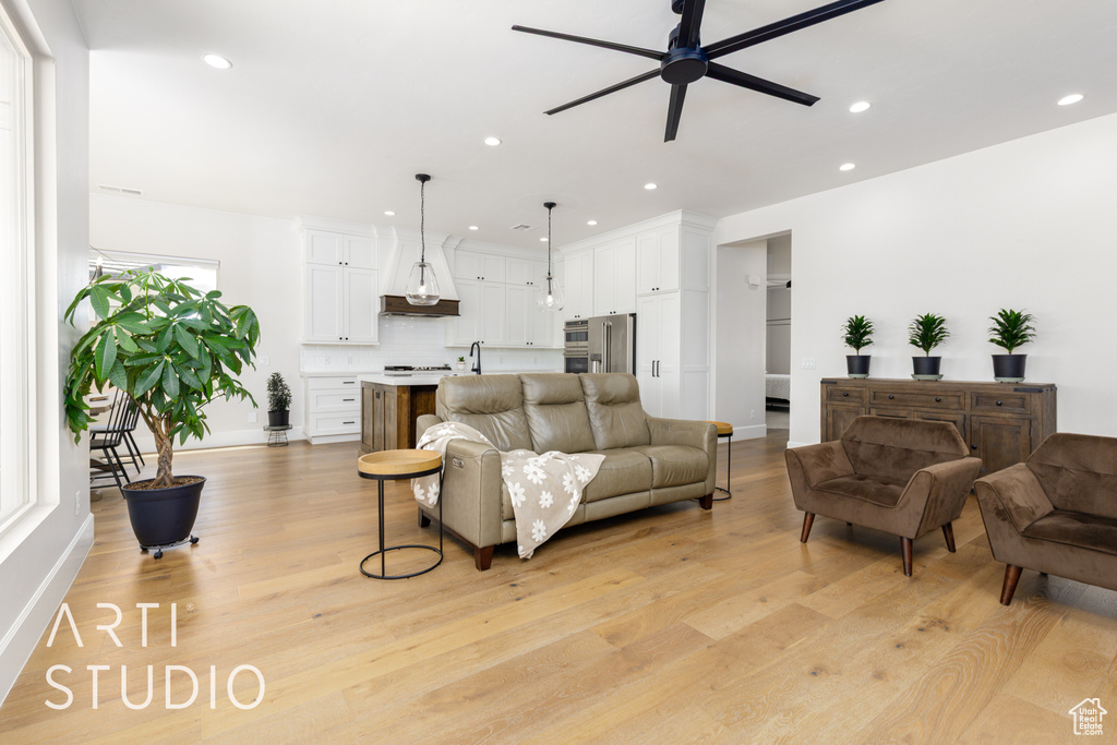 Living room featuring recessed lighting, a ceiling fan, and light wood-style floors