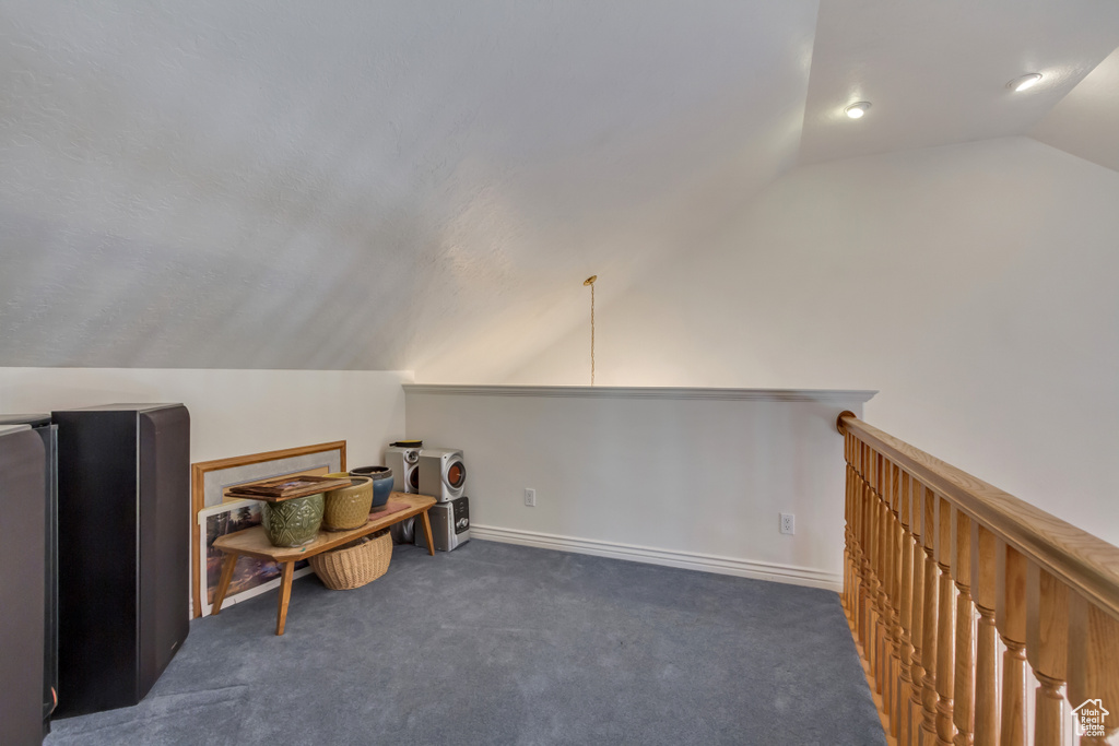 Carpeted office space with lofted ceiling
