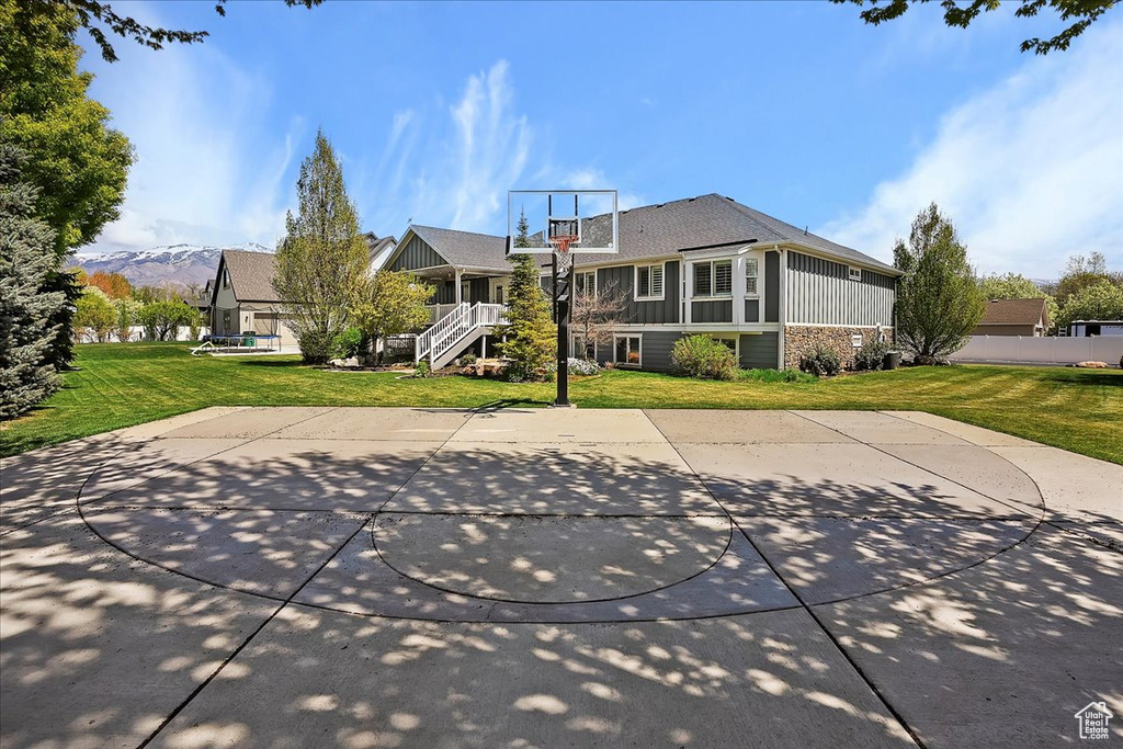 View of sport court featuring a yard and basketball court