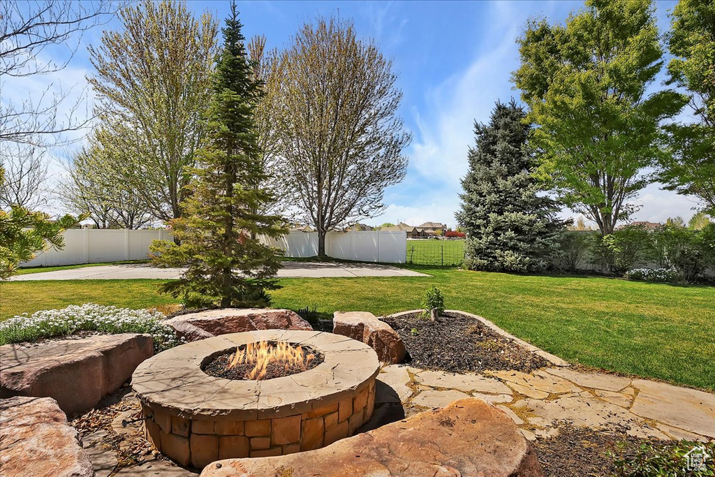 View of yard featuring a patio area, a fenced backyard, and an outdoor fire pit