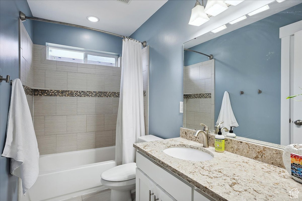Full bathroom featuring shower / bath combo, vanity, toilet, and recessed lighting