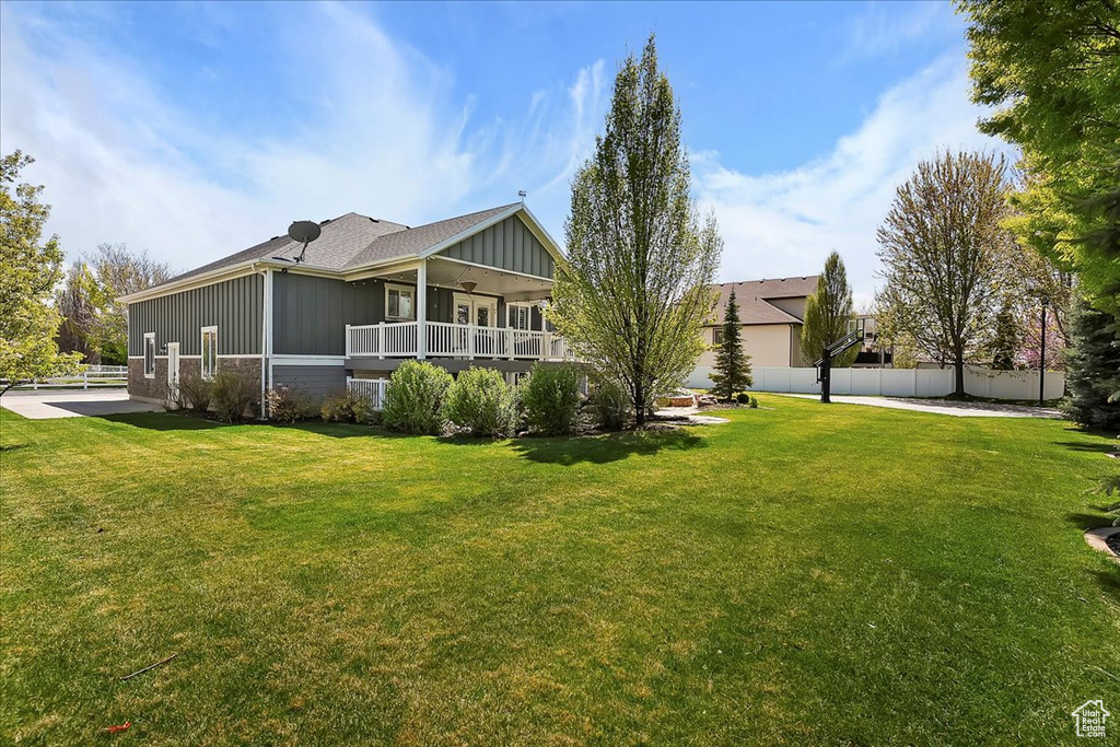 Back of house with fence, board and batten siding, and a yard