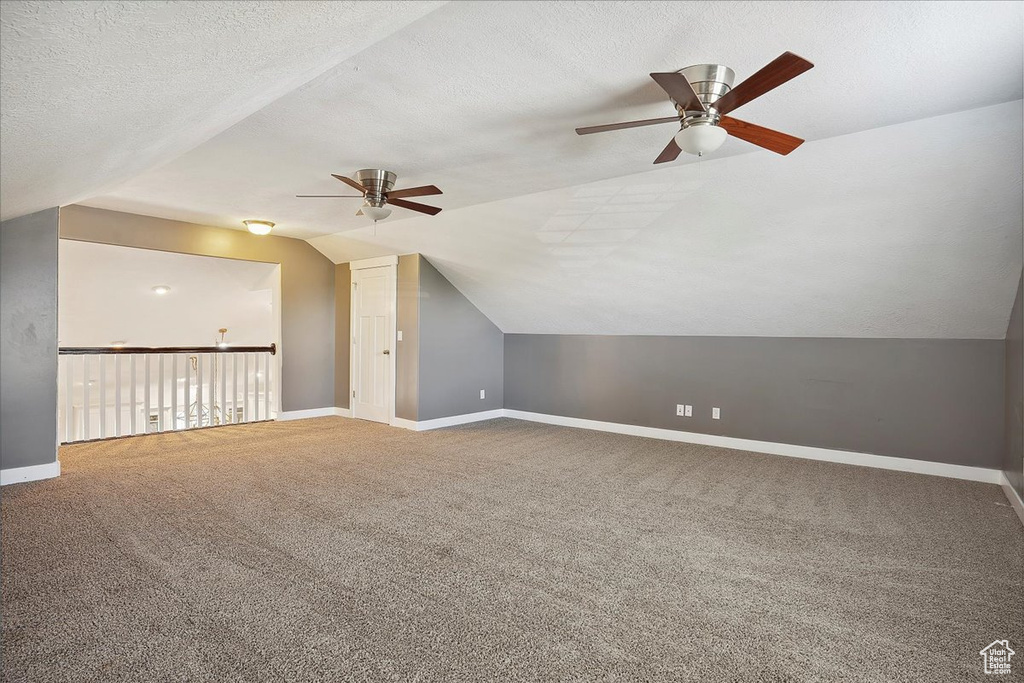 Additional living space featuring lofted ceiling, ceiling fan, baseboards, and carpet floors