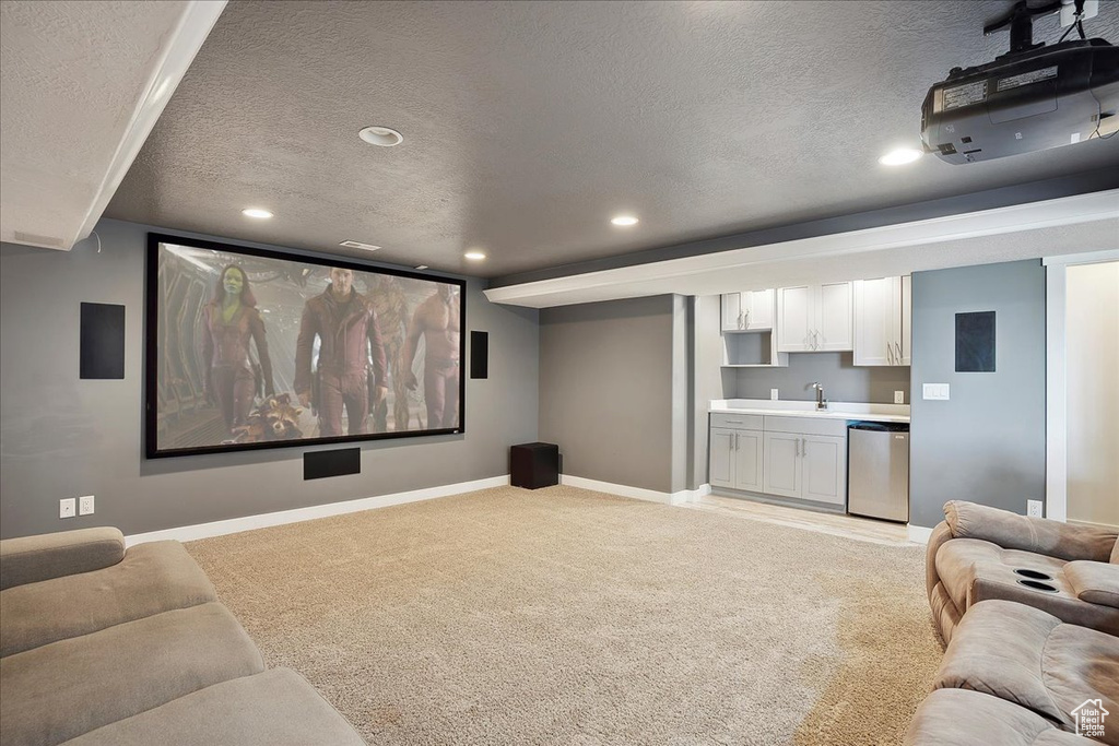 Cinema room with recessed lighting, a textured ceiling, light colored carpet, and baseboards