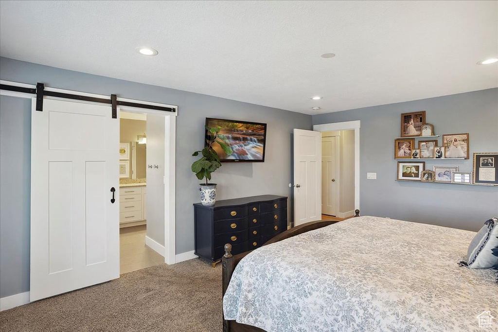 Carpeted bedroom featuring baseboards, a barn door, and recessed lighting