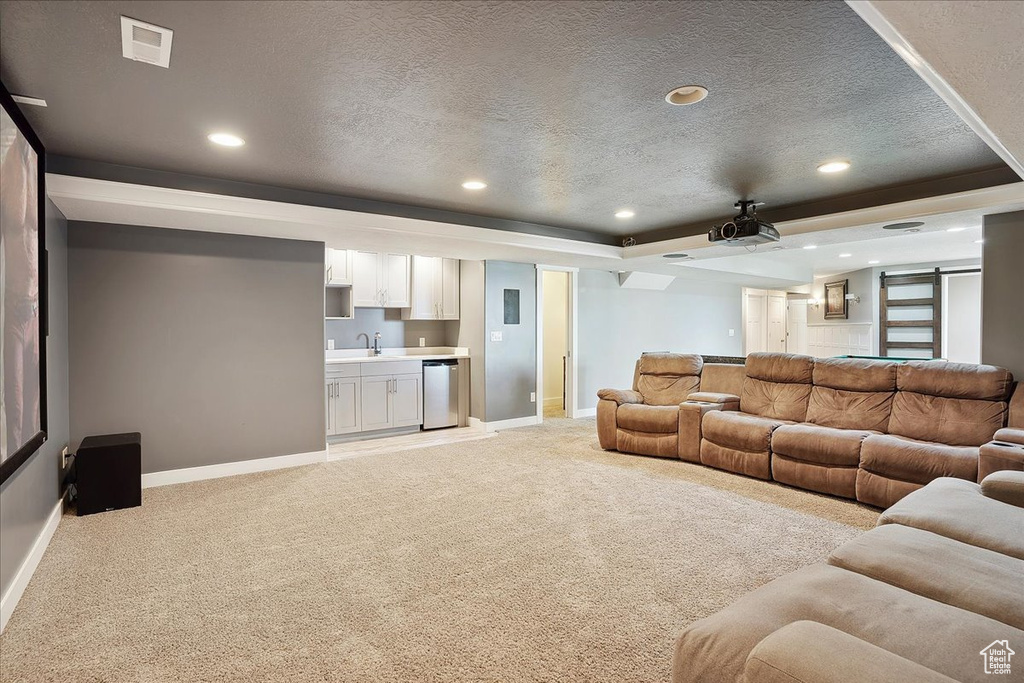 Living room featuring a textured ceiling, visible vents, light carpet, and baseboards