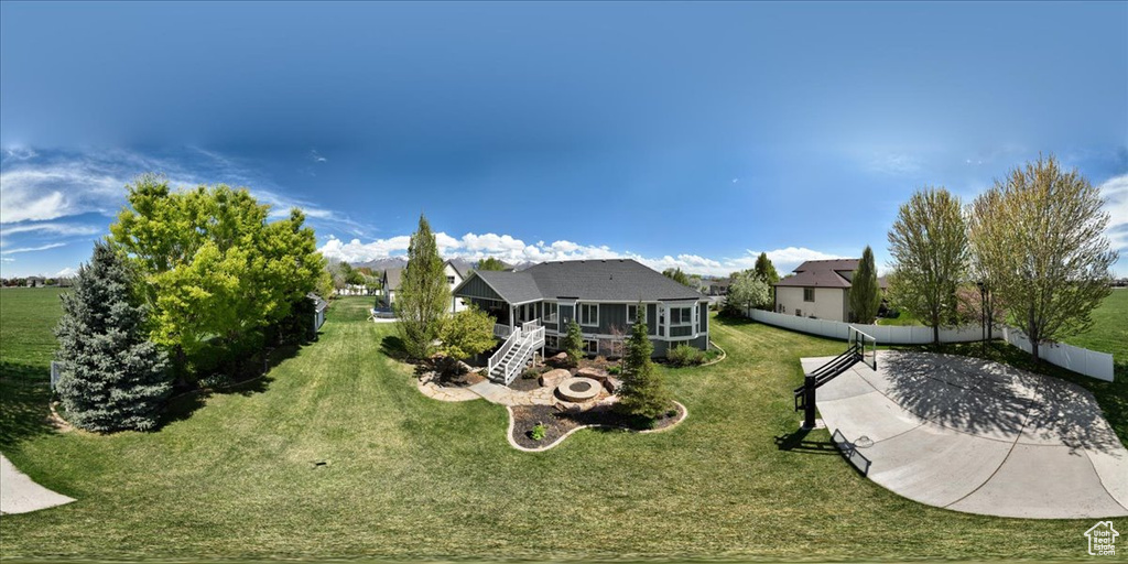 Rear view of house with stairs, a wooden deck, fence, a yard, and a sunroom