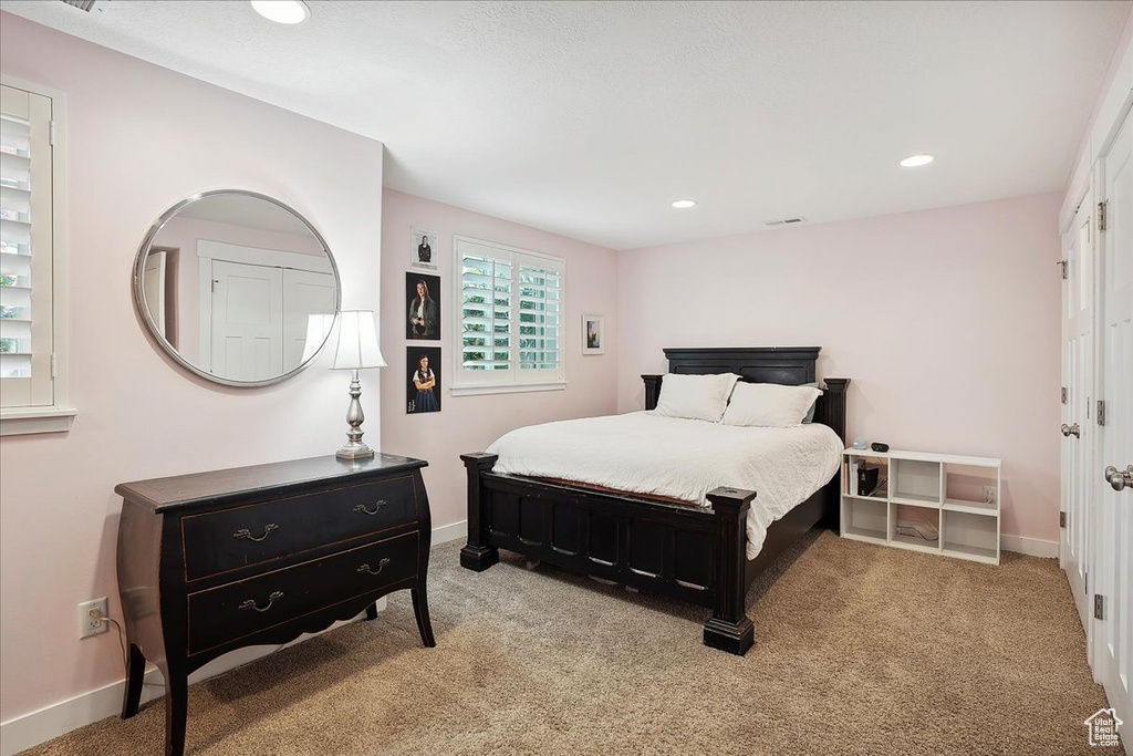Bedroom featuring baseboards, recessed lighting, and light carpet