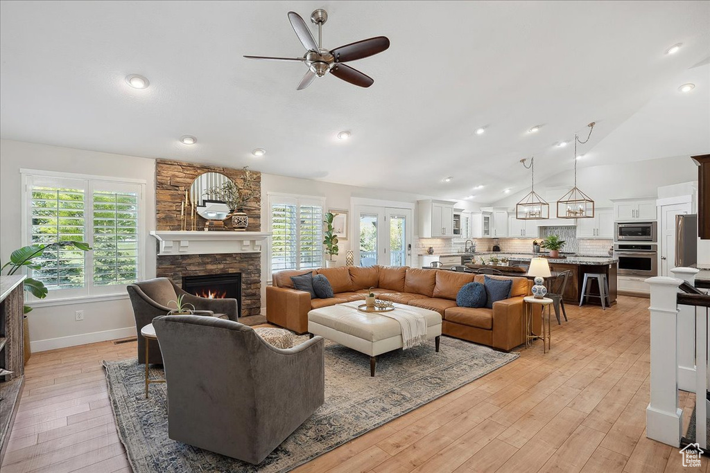 Living room featuring recessed lighting, light wood-style floors, a fireplace, ceiling fan, and vaulted ceiling