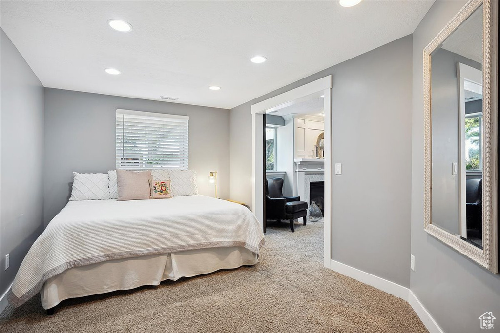 Bedroom with recessed lighting, multiple windows, light carpet, and baseboards