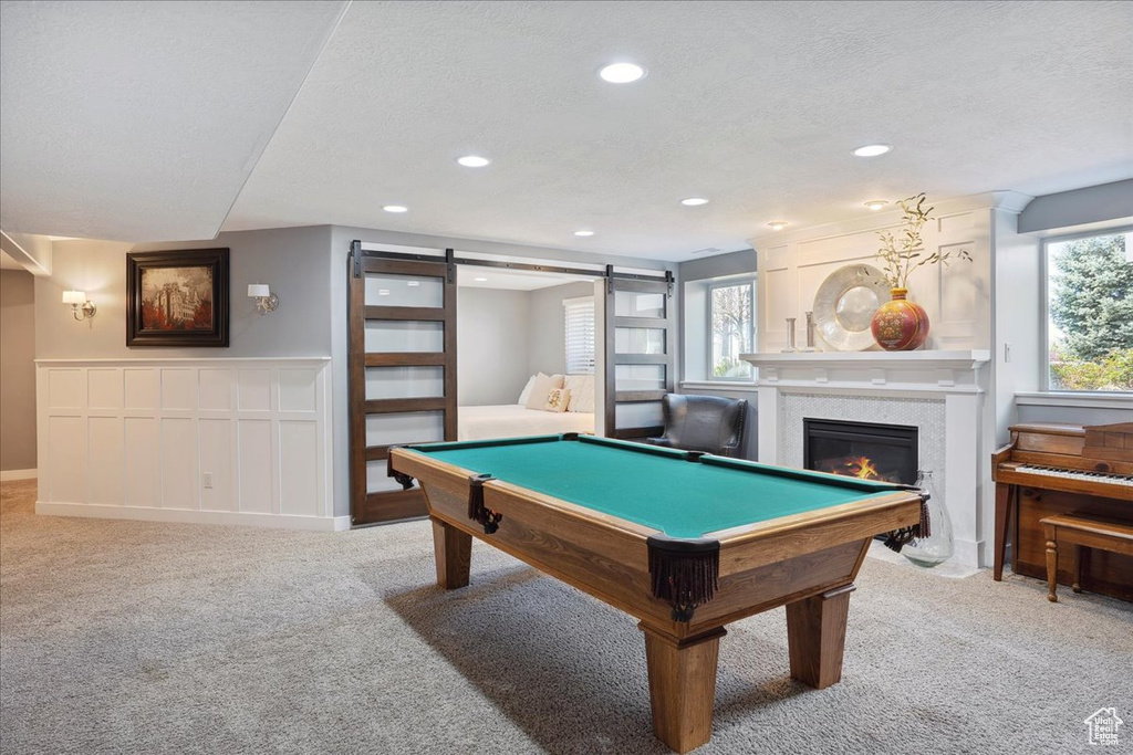 Playroom featuring light colored carpet, a barn door, and pool table