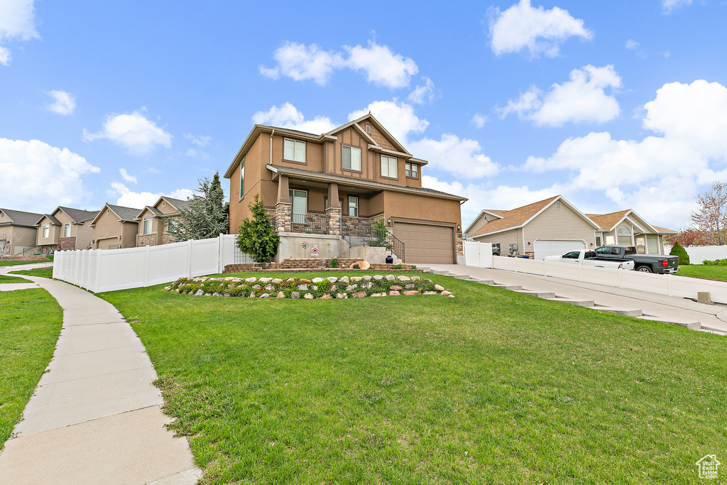 View of front of property featuring stucco siding, fence, a residential view, a front yard, and concrete driveway