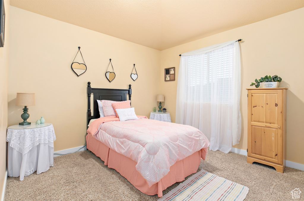 Bedroom featuring light carpet and baseboards