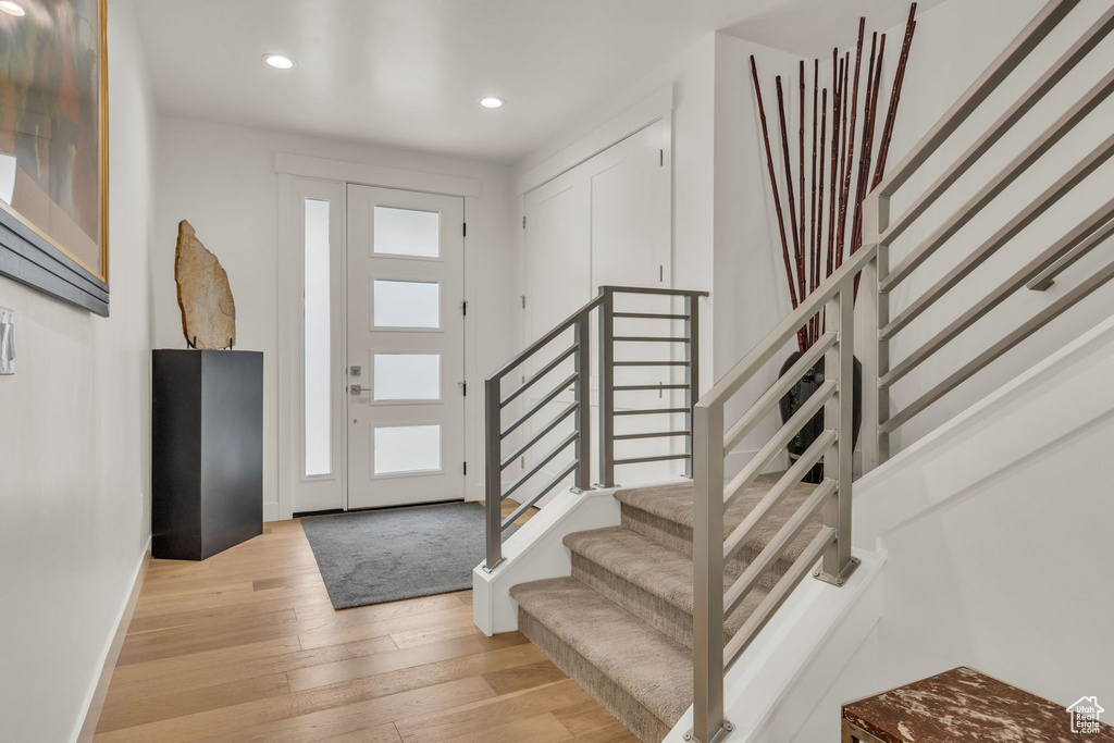 Foyer entrance featuring stairs, recessed lighting, baseboards, and light wood-style flooring