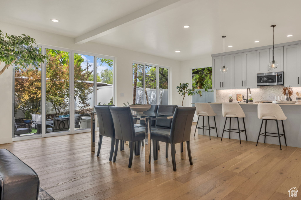Dining area with recessed lighting, beamed ceiling, and light wood-style floors