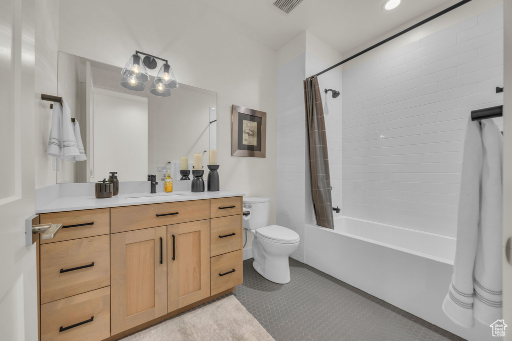 Full bathroom with tile patterned flooring, shower / tub combo with curtain, vanity, toilet, and visible vents