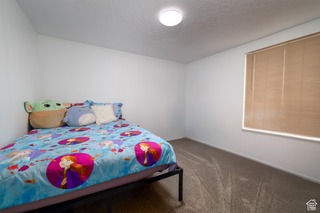 Bedroom featuring a textured ceiling and carpet