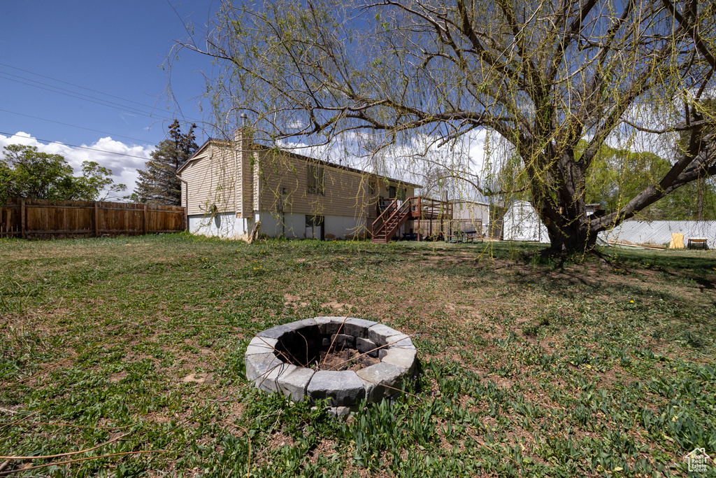View of yard featuring stairway, fence private yard, and an outdoor fire pit