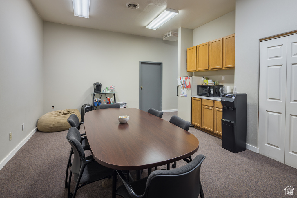 Dining room featuring carpet floors, visible vents, and baseboards