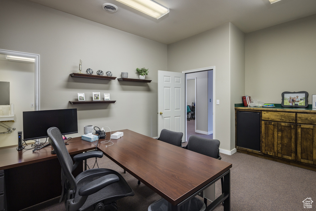 Office space featuring baseboards, visible vents, and carpet floors