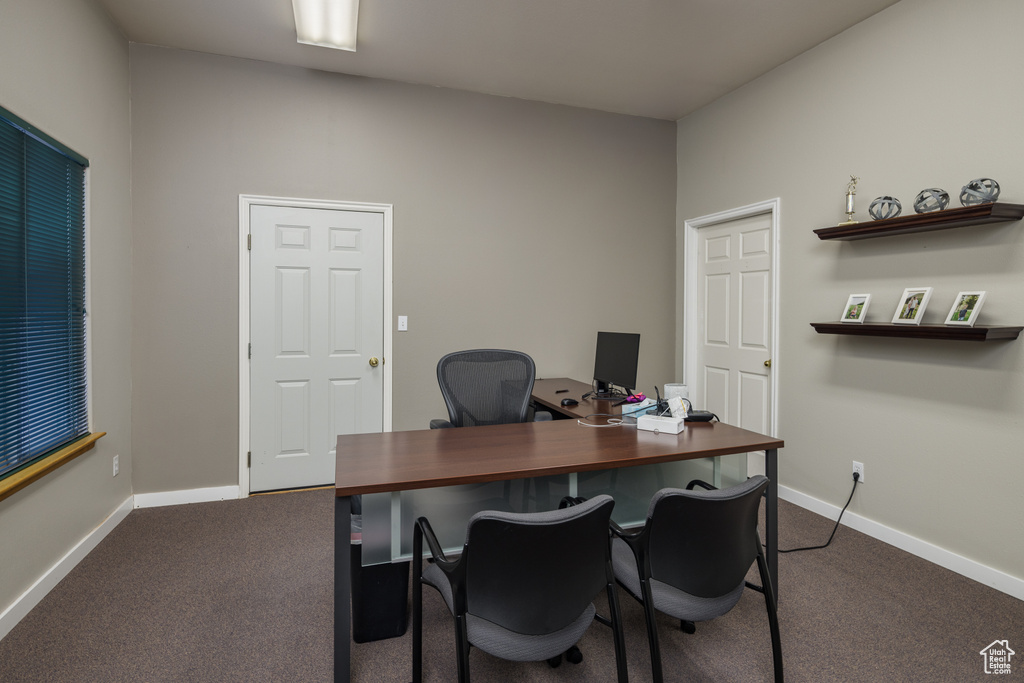Office space with dark carpet and baseboards